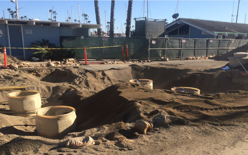 Open trench with new piping and conduit being installed.
